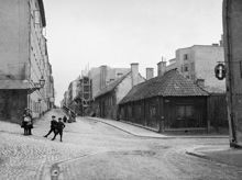 Några barn står i gathörnet där Brännkyrkagatan går österut från Timmermansgatan.