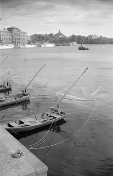 Vid Strömkajen ligger båtar med fiskehåvar. Nationalmuseum i fonden