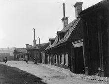 Prästgårdsgatan 28, 30 och 32 västerut. Husen revs 1902. Här ligger nu korsningen mellan Maria Prästgårdsgata och Rosenlundsgatan. Då kv. Suggan. Nu kv. Grimman och kv. Piskan