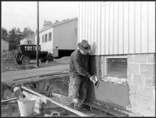 Putsning av murgrunden pågår av hus i småstugeområde