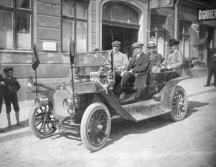 Fotografi av röda bilen nr 2 utanför Södra Folkets hus. I baksätet Zeth Höglund och Karl Kilbom. 