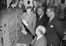 Archimedesvägen 6, LKB-produkter. Prof. H. Slätis (sittande) demonstrerar manöverbord till en ny betaspektrometer. Fr. v. Prof. K. Siegbahn, indiskminister E. Desai och Mr Martin