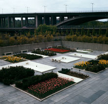 Dammar och blomsterrabatter i Folksam-husets gårdspark. Vy mot Skanstullsbron