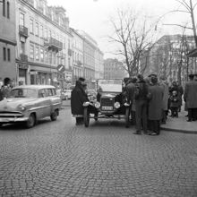 Hamngatan österut, korsningen vid Västra Trädgårdsgatan och Sagerska huset. Folksamling kring en gammal bil som stannat på gatan