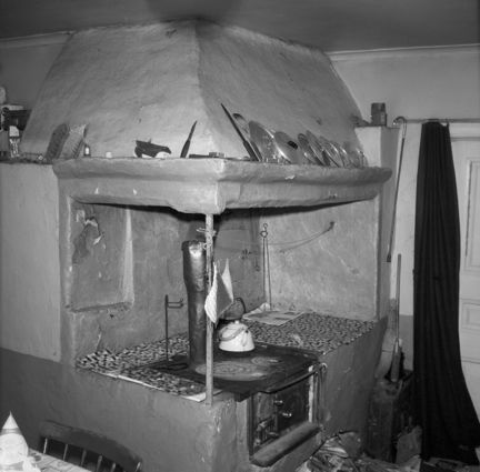 Interiör från köket i Anneboda gård med murad spiskåpa, vedspis och bakugn.