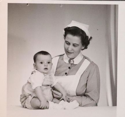 Svartvitt fotografi på barn med sköterska på Föreningen Barnavård