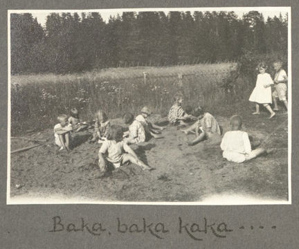 Barn sitter i sanden och leker.