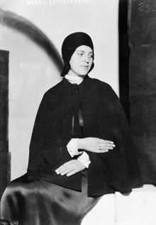 Porträtt av Bibbi Lindström, iklädd cape och hatt