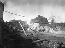 Sprängning för Wollmar Yxkullsgatans framdragning västerut mot Ringvägen. T.h. Wollmar Yxkullsgatan 26 och 28 i kv. Suggan som då låg mellan kv. Postiljonen och kv. Piskan. Nuvarande kv. Postiljonen