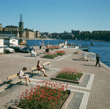 Klara Mälarstrand ("Stadshuskajen") med bänkar och planteringar. Vy åt söder. I bakgrunden syns Riddarholmskyrkan under renovering