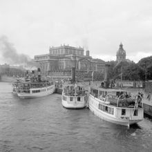 Ångbåtar vid Södra Blasieholmshamnen. Operan, Jakobs kyrka och Karl XII:s Torg i fonden