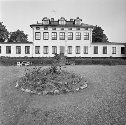 Svartvitt foto över gårdsplan framför byggnaden