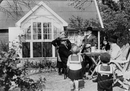 Flera generationer samlade framför en kolonistuga i Dalen, 1934