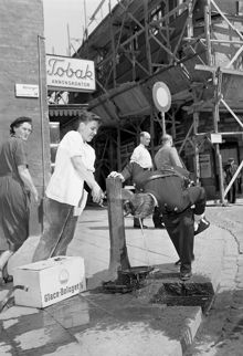 Hötorget. Glassförsäljaren Rune Svensson hjälper polismannen Roland Lannerström att dricka ur vattenpump