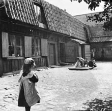 Några barn leker på gårdssidan av Fjällgatan 6. Nuv. Mäster Mikaels Gata 6