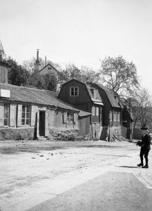 En pojke står på Folkungagatan österut från Ersta Backe. Folkungagatan 77, 79 och 81. Nu Folkungagatan 137