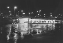 Motiv från Slussen i kvällsbelysning. Vy mot söder. Blå Bodarna med Stockholms-Tidningens och Aftonbladets depeschbyrå