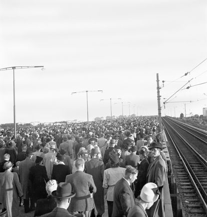 Ett folkhav intill järnvägsspår.