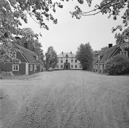 Svartvitt foto över gårdsplan framför byggnaden