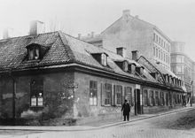 En man passerar Timmermansgatan 29. Timmermansgatan 29-31 söderut från Wollmar Yxkullsgatan