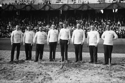 Svenska guldmedaljörlaget i dragkamp vid Olympiska spelen i Stockholm 1912. Från vänster: A.L. Andersson, E.V. Larsson, E.A. Fredriksson, A. Gustafsson, C.H. Lindström, J.V. Edman, A.Bergman, K. Jonsson.
