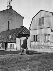En man passerar vid Ölandsgatan 17 C. Vy västerut från Götgatan. Motsvarar nuv. läget för Ringens köpcentrum vid Götgatan 100