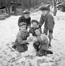 Fem pojkar gör en snögubbe i snön