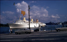 M/S Kungsholm för ankar utanför Slussen. Bilar i förgrunden på Skeppsbron.