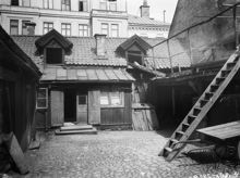 Gårdssidan av Smålandsgatan 17 i hörnet av Regeringsgatan. Huset revs 1904. Gatan är igenlagd och här ligger idag NK-varuhuset