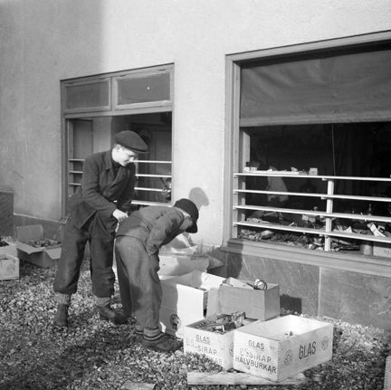 Två barn tittar på förstörelsen efter den sovjetiska bombfällningen över Eriksdalsområdet 1944 .
