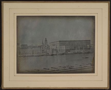 Kungliga Slottet och Storkyrkan sett från Skeppsholmen, tvärs över vattnet.