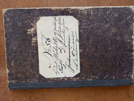 Ett brunt häfte med text: ”No 56 grönt Möbeltyg     Drottningholm Rödt d         Söderhjelm D            Prins Eugen Johansson 5 ändor Lindberg"