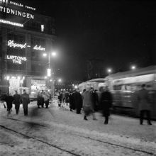 Folkliv på Tegelbacken. T. v. Neonskyltar på Centralpalatset