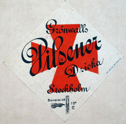 Etikett tryckt i rött och svart med kors och termometer samt text.