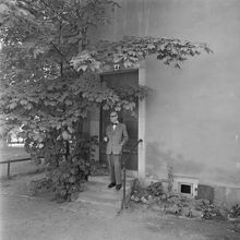 Regissör Gösta Terserus framför porten till sin bostad på Hovslagargatan 4.