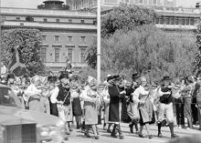 Reportage kring Kungabröllopet den 19 juni 1976. Ett spelmanslag tågar över Norrbro. I fonden Operahuset