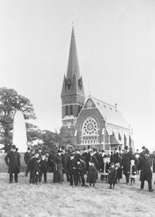 Gustav Adolfs kyrkan sedd med folksamling i förgrunden