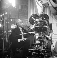 Södra Blasieholmshamnen 8, Grand Hotel. Filminspelning av filmen ""Jag är eld och luft"" i Spegelsalen. Regissör Anders Henrikson dirigerar tagning bakom kameran