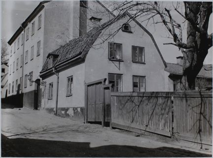 Träplank till höger, hus i enplan längs gatan