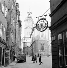 Hörnet Skomakargatan - Stortorget mot Trångsund och Storkyrkan. I förgrunden skylt för Fratis källare. Till vänster en parkerad bryggeribil med reklam för Carnegie porter
