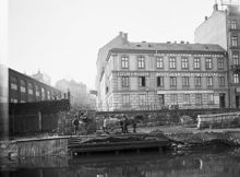 Utsikt från Gamla Kungsholmsbrogatan västerut mot Kungsholmsgatan 2 och Kungsbroplan 1. T.v. AB Bolinders maskinhallar. T.h. cigarrfabrik, snickeriverkstad samt rullgardinsfabrik. Nu Kungsbro Strand