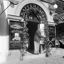 Hötorget 10, Carl Salén Kaffehandel. Carl Salén sköter om sina rosenbönor och bondbönor som slingrar sig kring ingången till hans butik