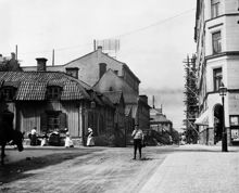 Linnégatan västerut vid korsningen Skeppargatan. Trähuset t.v. ligger vid Skeppargatan 35 - Linnégatan 52. Nu Skeppargatan 43. Byggnadsställningar är resta vid Linnégatan 39