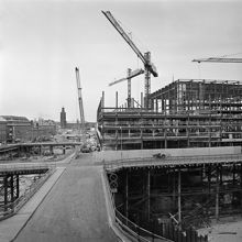 Brunkebergstorg med provisoriska broar i förgrunden. Vattugatan går västerut från Brunkebergstorg 7. T.v. ligger Herkulesgatan. Kv. Wahrenberg och Elefanten är rivna. I fonden ses Stadshuset