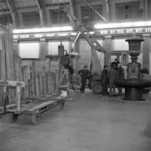 Centralstationen. Byggnadsarbetare utför pålningsarbete nattetid i vänthallen. T.h. på bilden finns en dricksvattenfontän. (Fontänen är gjord av jämtlandskalksten och är tre meter hög)