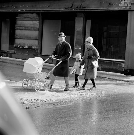 Man med barnvagn, kvinna och barn går efter.