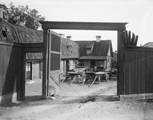 Jaktvarvsgränd 3. Vy från porten i planket in mot gården med två vagnar. Jaktvarvsgränd gick parallellt med Polhemsgatan söderut från Hantverkargatan. Uppgick i kv. Fortifikationen