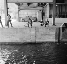 Människor som sitter och metar vid Slussen