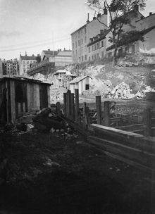 Anläggningsarbete vid Kungsgatans framdragande. Lutternsgatan sprängdes och urschaktades genom Brunkebergsåsen 1905-1911. T.h. Lutternsgatan 12 A och B i kv. Kåkenhusen, nu Kungsgatan 8-10