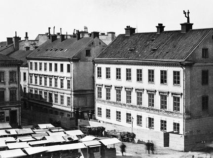 Längst fram syns torghandel. I fonden ligger några stenhus i tre våningar.